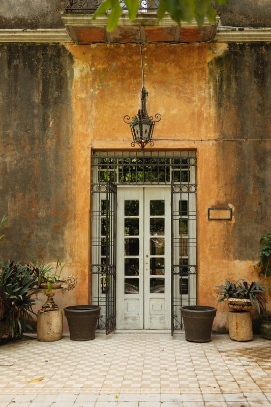 Puerta con farol de hierro y macetas